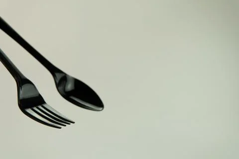 Selective focus of black shine spoon and fork with white background. Stock Photos