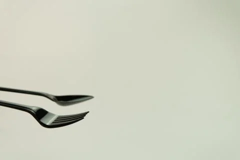 Selective focus of black shine spoon and fork with white background. Stock Photos