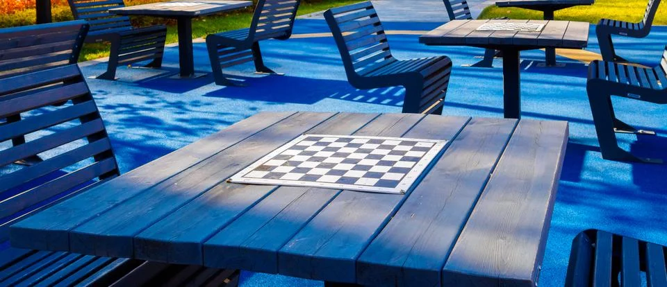 Selective focus on a blank chessboard on the table outdoors. Stock Photos