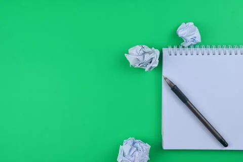 Selective focus of blank note book, a pen and unused paper on a green backgro Stock Photos