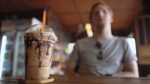 Selective Focus of Blended Coffee Beverage in Plastic Cup and Straw in Cafe Stock Footage 126574817