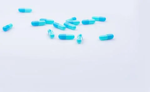 Selective focus on blue capsule pill on white background. Pharmaceutical indu 库存照片