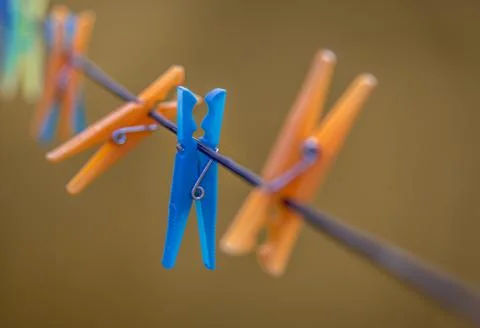 Selective focus of a blue plastic clothespin on a rope in an array of colorful o 写真素材