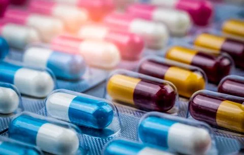 Selective focus on blue-white capsule pills in blister pack. Pharmaceutical i Stock-Fotos