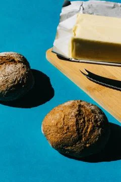 Selective focus of bread and butter, typical French breakfast. On blue backgr Stock Photos