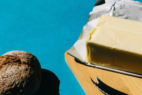 Selective focus of bread and butter, typical French breakfast. On blue backgr Stock Photos