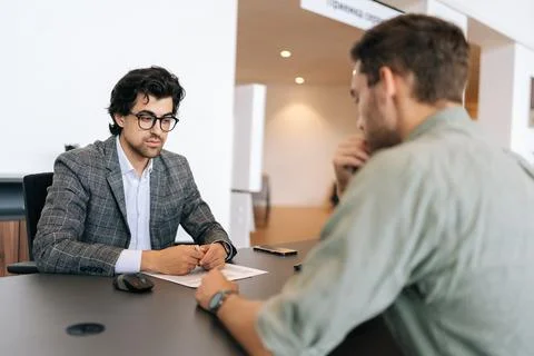 Selective focus of broker advisor in eyeglasses and business suit consulting to Stock Photos