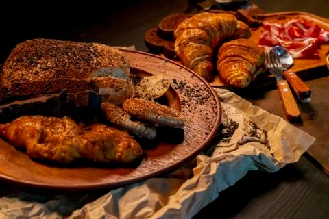 Selective focus of Brown bread in wooden dish on table in the dark. Stock Photos
