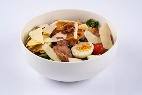 Selective focus Caesar salad with roasted chiken, bacon, quail eggs, lettuce  Stock Photos