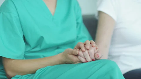 Selective focus as the camera pans from hands to nurse to patient to doctor and Stock-Footage 32961941