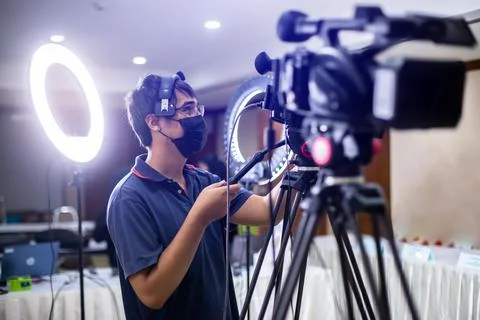 Selective focus to cameramans working with camera and blurry ring lighting .. Stockfoto's