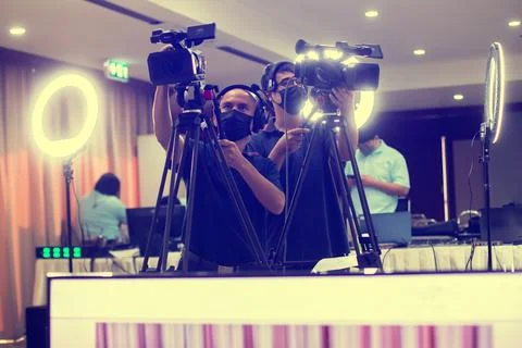 Selective focus to cameramans working with camera and blurry ring lighting .. Stock-Fotos