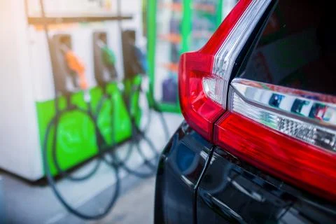 Selective focus to the car with blurry refilling the car and fuel at the gas  Stock Photos