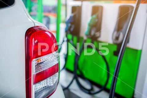 Selective focus to the car with blurry refilling the car and fuel at the gas Stock Photos