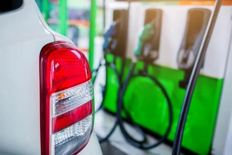 Selective focus to the car with blurry refilling the car and fuel at the gas  Stockfoto's