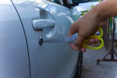 Selective focus on car key remote and tools in man's hand open the car door.  Stock Photos