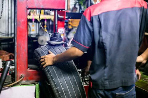 Selective focus to car tire patch machine with blurry mechanic working in car Фото