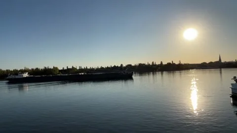 Selective focus cargo barge sailing along the Rhine River at sunrise Stock Footage 345591795