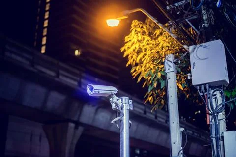 Selective focus to CCTV Camera with blurry lamp and building. Foto stock
