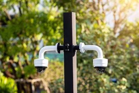 Selective focus to CCTV Camera with blurry green tree. Stock Photos