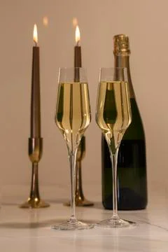 Selective focus of champagne glasses with two out of focus lit candles and a  Stock Photos