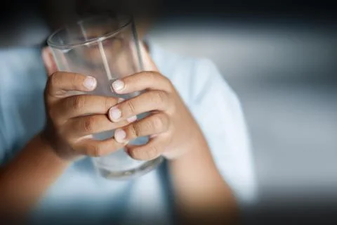 Selective focus of child holding empty drinking glass Foto stock