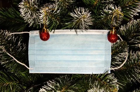 Selective Focus Christmas tree decorated with protective medical mask. Stock Photos