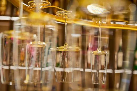 Selective focus of clean empty wine glasses hanging in bar counter Stock Photos