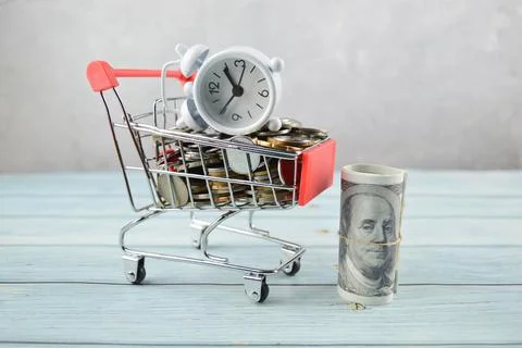 Selective focus of clock, coins and money banknotes. Financial concept. Stock Photos