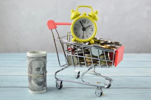 Selective focus of clock, coins and money banknotes. Financial concept. Stock Photos