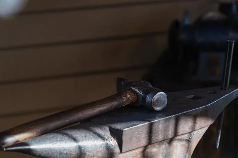 Selective focus close-up of a blacksmith's hammer on a metal anvil Stock Photos