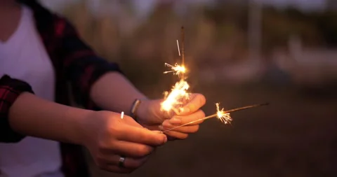 Selective focus, Close up female' hands holding and play with fireworks burning Stockbeeldmateriaal 221380404