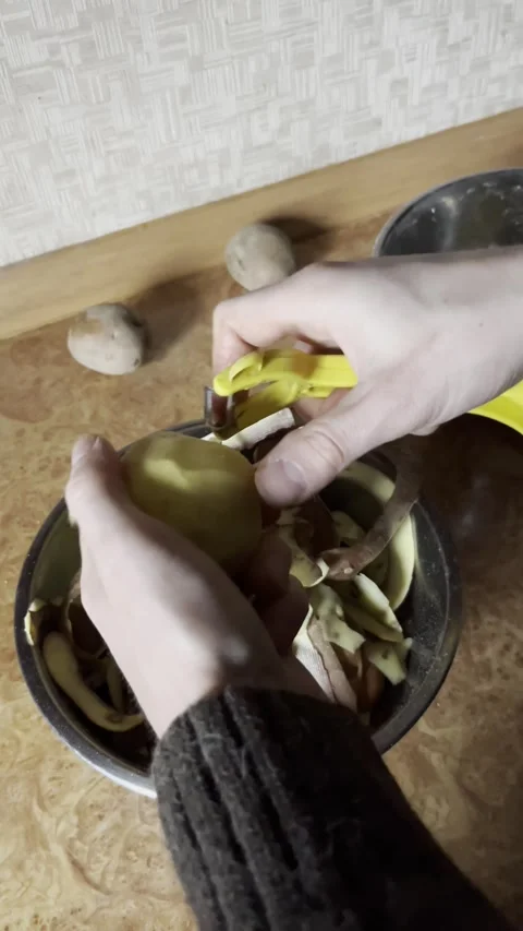 Selective focus close-up of hands cleaning potatoes Stockbeeldmateriaal 334327518