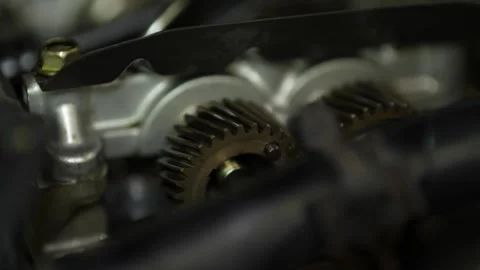 A selective focus close-up highlights interlocking metallic camshaft gears in Video stock 345109443