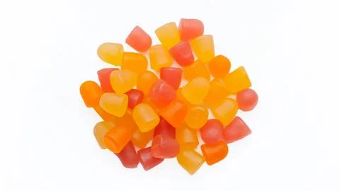 Selective focus, close-up texture of orange and yellow multivitamin gummies on Stock Photos