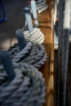 Selective focus close up view of ropes wrapped around wooden belaying pins on Stock Photos