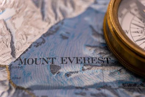 Selective focus close up of vintage compass on map detail of Mt. Everest 库存照片