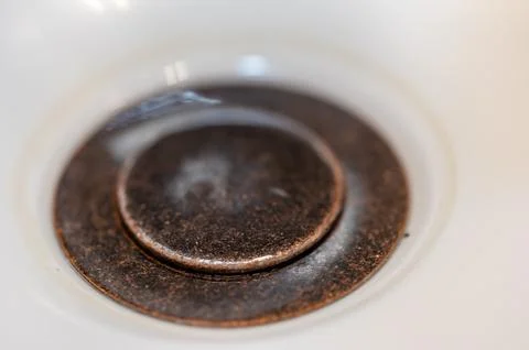 Selective focus on a closed bronze sink drain. Foto stock
