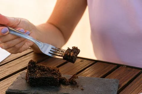 Selective focus. Closeup on fork with piece of cookie cake, next to a slate s Stock Photos
