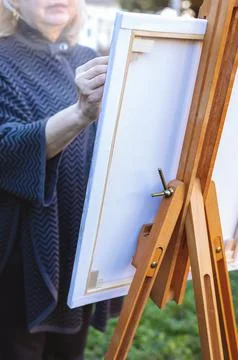 Selective focus closeup of the hands of an elderly woman artist painting a Stock Photos