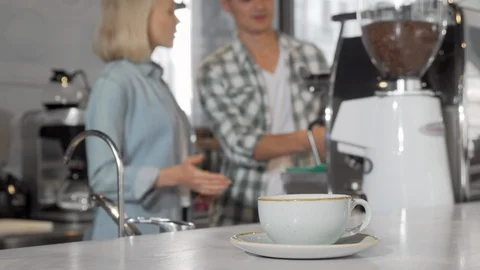 Selective focus on a coffee cup two baristas working on background Stock Footage 116894007