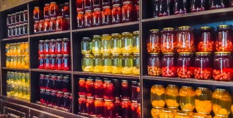 Selective focus. Compote of berries and apples in jars. Several Colorful cans of Stock Photos