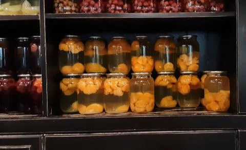 Selective focus. Compote of berries and apples in jars. Several Colorful cans of Stock Photos