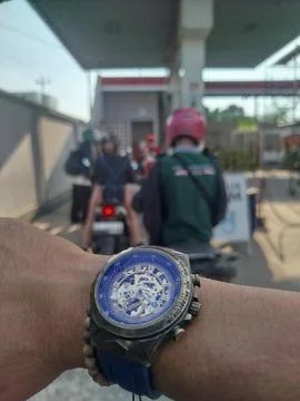 Selective focus. Concept and idea wristwatch at the gas station. Stock Photos