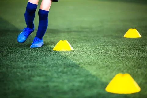 Selective focus to cone marker with blurry boy soccer player is jogging on gr Stockfoto's