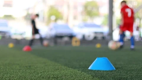 Selective focus to cone marker on green artificial turf with blurry soccer team  Stock Footage 144759832