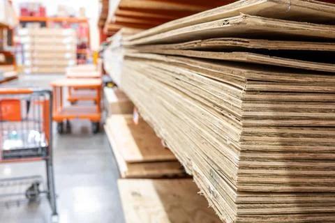 Selective focus on corner edge of stacked plywood at a lumberyard hardware store Foto stock