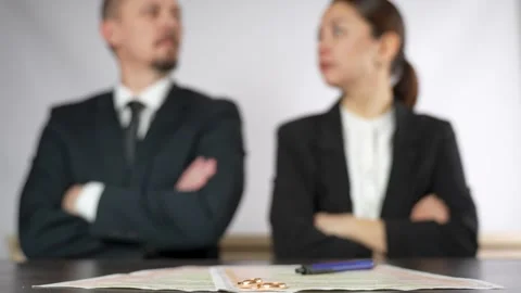 Selective focus of couple sitting at table with divorce documents and weddi.. Stock Footage 273198327
