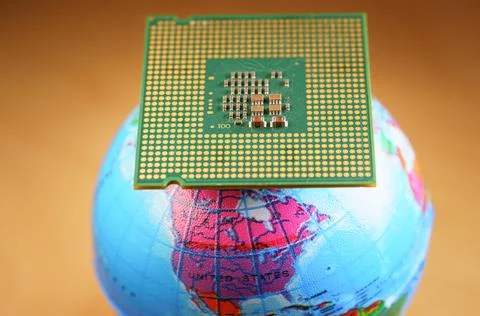 Selective focus of a CPU on top of a world globe against an orange background Stock Photos