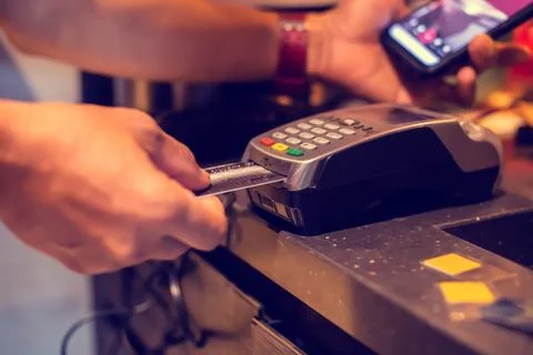Selective focus to credit card reader with blurry hand put credit card In s.. Фото